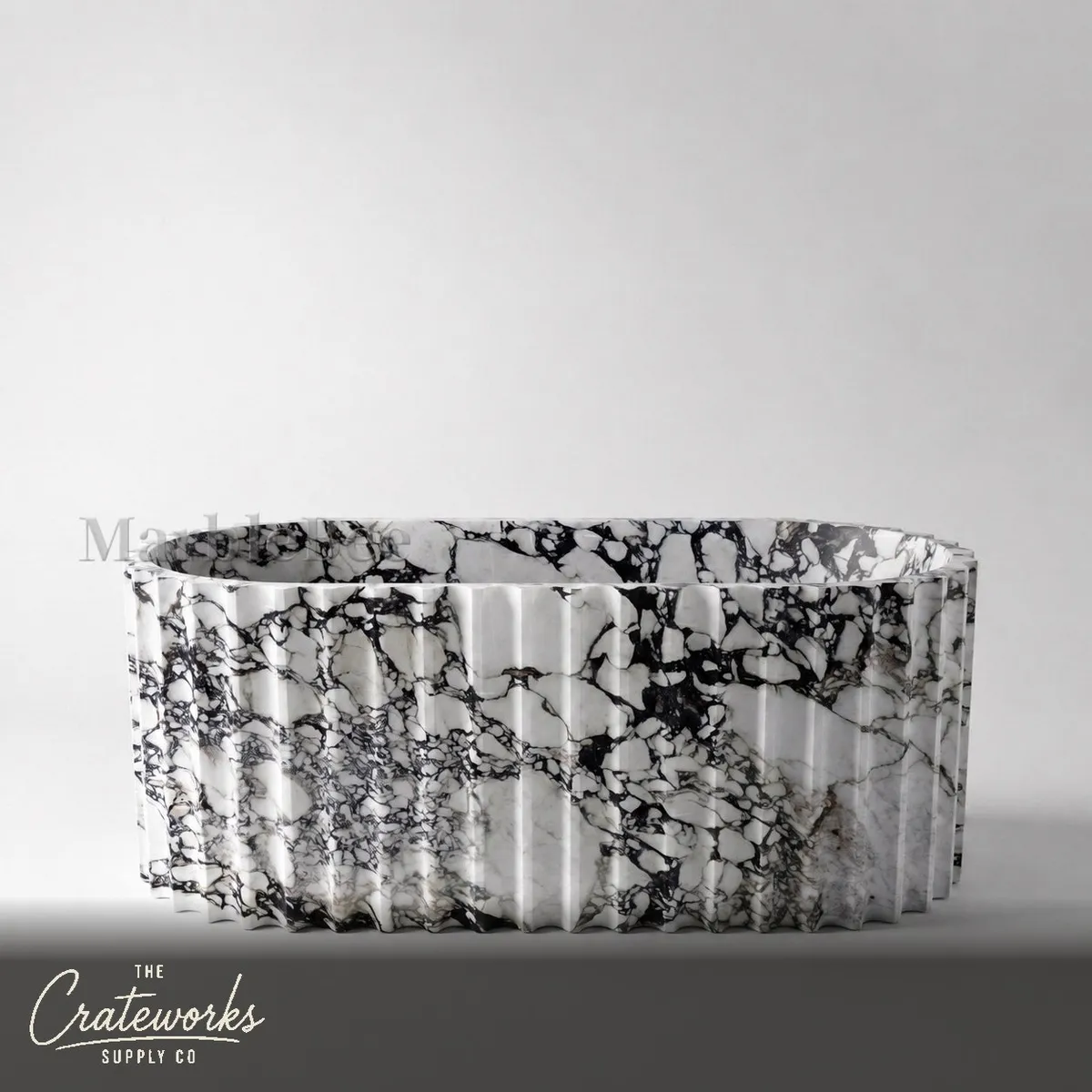 White marble bathtub with fluted sculptural design